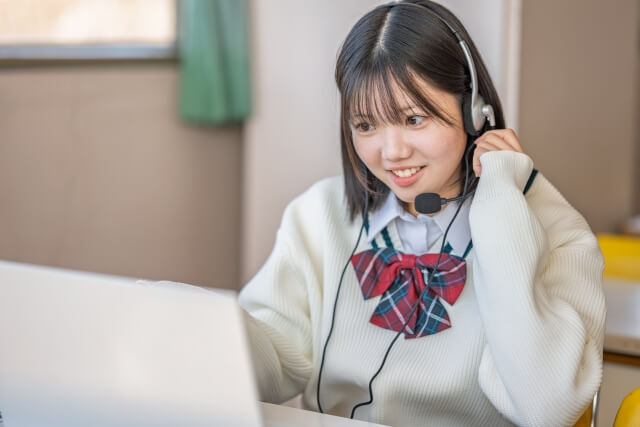 ノートパソコンで会話する女子学生