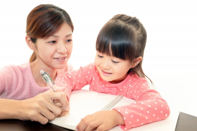 母親と一緒に勉強する幼い娘