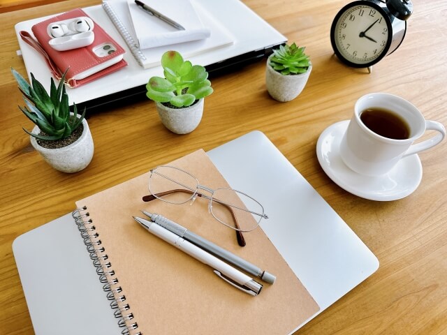 机の上に置かれたノートと植物