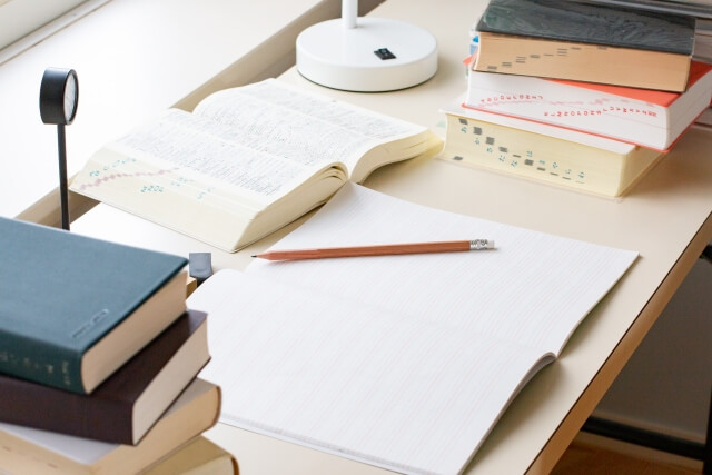 机の上の開いた本と鉛筆