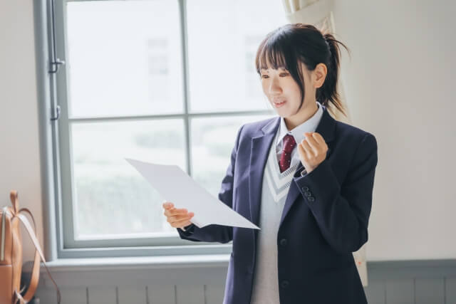 教室でプレゼンテーションをする女子学生